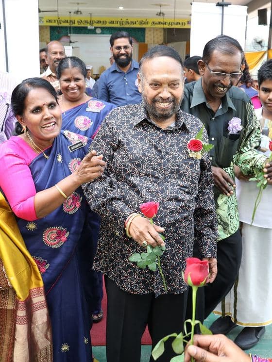 Guests holding roses at a Malaysian community celebration